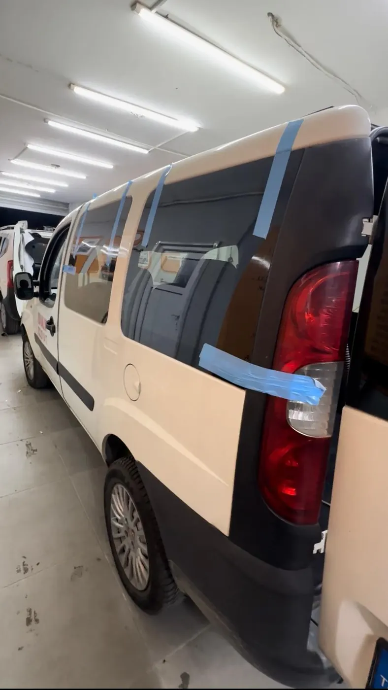 Cam montajı tamamlanmış beyaz Fiat Doblo